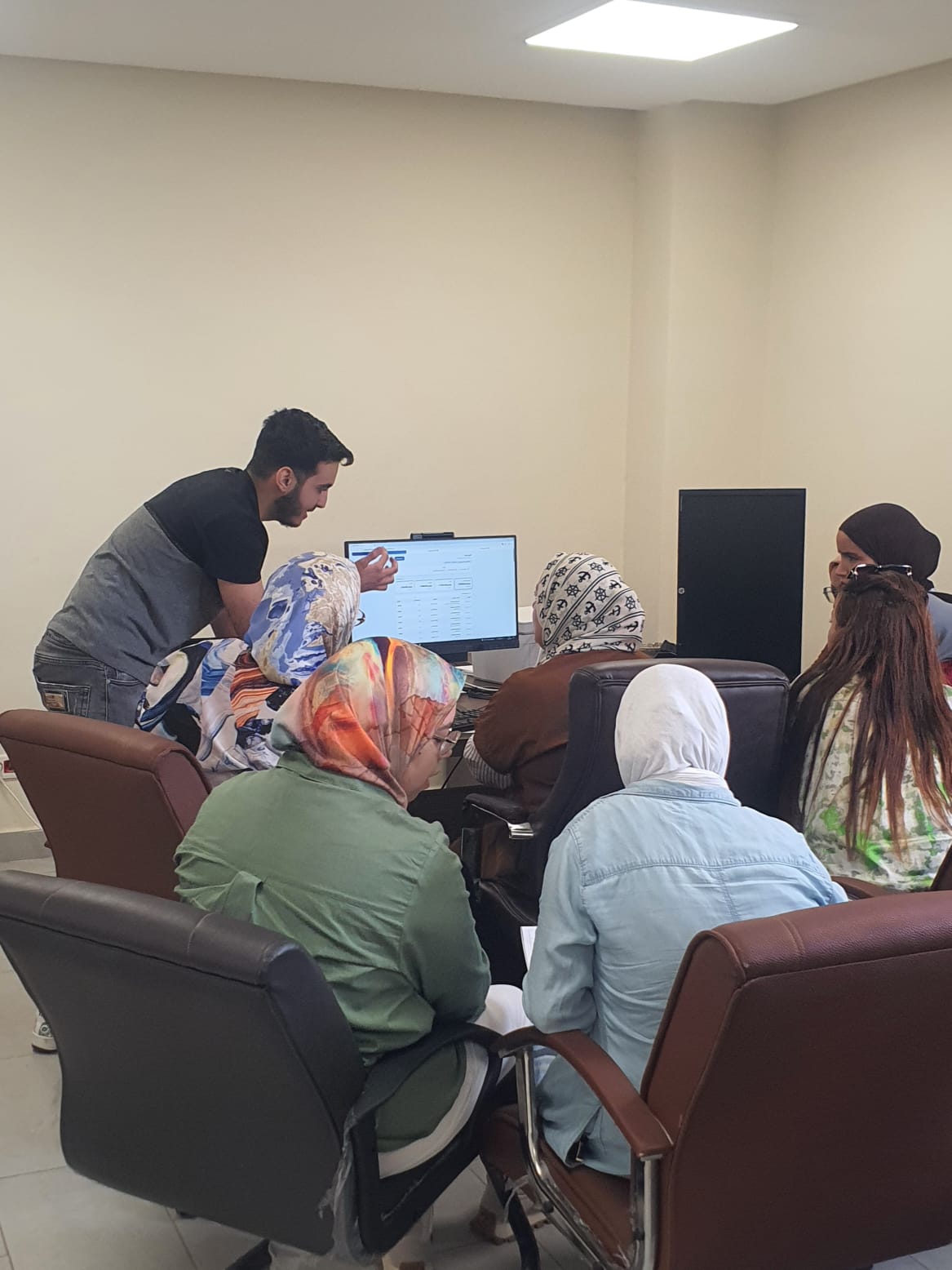 A Sanad Idari trainer guiding a taxation-office team through GeoMiz