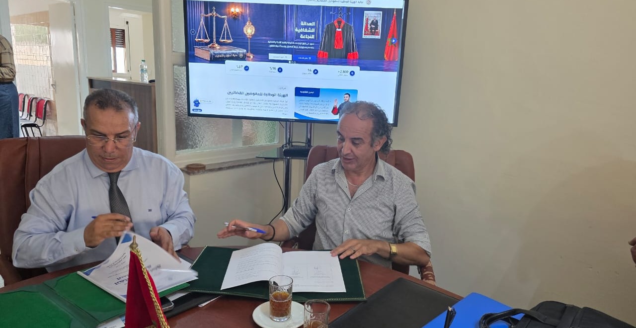 The two parties reviewing partnership documents at the signing table